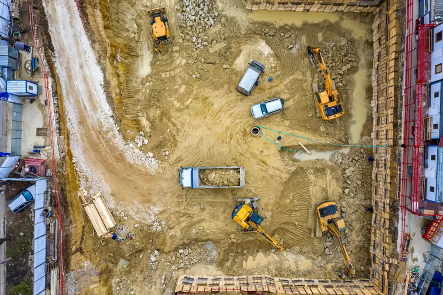 Luftaufnahme einer Baustelle der Maim GmbH mit Baggern und Kipplaster